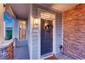 Inviting entryway with stylish front door, decorative wreath, and brick accents at 12059 S Tallkid Ct, Parker, CO 80138
