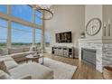 Stunning living room with fireplace, vaulted ceilings, large windows, and hardwood flooring showcasing scenic views at 12059 S Tallkid Ct, Parker, CO 80138