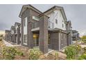 Townhome exterior with brick facade, a balcony, and modern architectural details on a cloudy day at 5107 S Fairplay St, Aurora, CO 80015