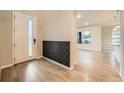 Bright foyer featuring hardwood floors, decorative wall paneling, and an open view to the living area at 5107 S Fairplay St, Aurora, CO 80015