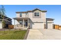 Inviting two-story home with a covered front porch, three car garage and manicured lawn at 4635 Cattle Cross Trl, Castle Rock, CO 80104