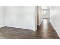 Bright hallway featuring laminate wood flooring and white walls, creating a clean aesthetic at 4635 Cattle Cross Trl, Castle Rock, CO 80104