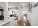 Bright hallway featuring hardwood floors, white columns and views of the dining area at 2810 Shadow Dance Dr, Castle Rock, CO 80109