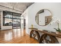 Inviting entryway featuring hardwood floors, decorative console table and round mirror at 1863 Wazee St # 4E, Denver, CO 80202