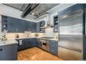 A modern kitchen featuring stainless steel appliances, sleek cabinetry, and beautiful hardwood floors at 1863 Wazee St # 4E, Denver, CO 80202