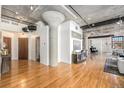 Spacious living area showcasing hardwood floors, concrete pillars, and exposed ductwork at 1863 Wazee St # 4E, Denver, CO 80202