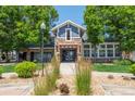 Clubhouse exterior with stone facade, blue siding, a pergola entrance, and well-maintained landscaping at 5255 Memphis St # 811, Denver, CO 80239