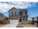 Charming two-story home with a stone facade, white garage door, and red front door at 27664 E Byers Ave, Aurora, CO 80018