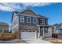 Charming two-story home with a stone facade, white garage door, and red shutters at 27664 E Byers Ave, Aurora, CO 80018
