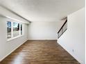 Living room features hardwood floors, staircase, and a large bright window at 630 S Youngfield Ct, Lakewood, CO 80228