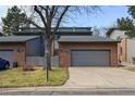 Charming brick-accented townhouse with attached garage and well-maintained front lawn and mature tree at 2609 S Quebec S St # 20, Denver, CO 80231