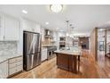 Open kitchen showcasing a large island, stainless steel appliances, and hardwood floors at 2609 S Quebec S St # 20, Denver, CO 80231