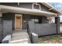 Charming home featuring an attractive painted brick exterior, covered front porch, and well-manicured landscaping at 3600 N Race St, Denver, CO 80205