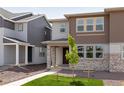 Attractive two-story house with a blend of stone and siding, highlighted by a green lawn and budding tree at 1415 Great Western Dr, Longmont, CO 80501