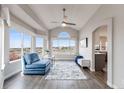 Cozy sitting area with vaulted ceiling, large windows, and a comfortable blue lounge chair at 6749 Shannon Trl, Highlands Ranch, CO 80130