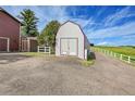 View of the barn with gray siding and a red metal roof at 35675 Cheyenne Trl, Elizabeth, CO 80107