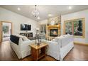Spacious living room with a stone fireplace, hardwood floors, and comfortable seating at 20190 Deer Shadow Way, Monument, CO 80132