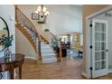 Elegant foyer with hardwood floors, a curved staircase with iron railings, and views into the dining and living areas at 10859 Irving Ct, Westminster, CO 80031