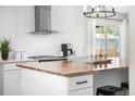 Bright kitchen featuring an island with a butcher block countertop, stainless steel appliances, and white subway tile backsplash at 5886 Urban St, Arvada, CO 80004