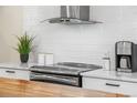 Updated kitchen features stainless steel appliances, white cabinets, and modern fixtures at 5886 Urban St, Arvada, CO 80004