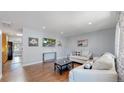 Bright living room boasts hardwood floors and stylish, neutral-toned furniture at 8438 Ames St, Arvada, CO 80003
