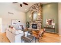 Open living room with vaulted ceiling, stone fireplace, and hardwood floors provide an inviting space for relaxation at 415 Butte Pkwy, Golden, CO 80403