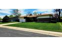 Charming single-story home featuring a two-car garage and a well-maintained front yard with a long driveway at 9584 W Kentucky Ave, Lakewood, CO 80226