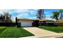 Charming single-story home featuring a two-car garage and a well-maintained front yard with a long driveway at 9584 W Kentucky Ave, Lakewood, CO 80226