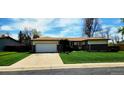 Charming single-story home featuring a two-car garage and a well-maintained front yard with a long driveway at 9584 W Kentucky Ave, Lakewood, CO 80226