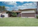 Ranch-style home with a well-maintained front yard, brick accents, and mature landscaping at 9584 W Kentucky Ave, Lakewood, CO 80226