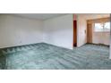 Spacious living room with plush carpeting and natural light from the window at 9584 W Kentucky Ave, Lakewood, CO 80226