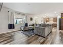 Bright living room with large windows, hardwood floors, and an open layout connecting to the kitchen at 6616 Amur Ln, Castle Rock, CO 80108
