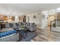 Open-concept living room with hardwood floors, modern furnishings, and seamless flow to the kitchen at 6616 Amur Ln, Castle Rock, CO 80108