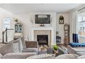 Cozy living room with a fireplace, comfortable seating, and hardwood floors at 6616 Amur Ln, Castle Rock, CO 80108