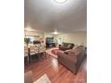 Open-concept living room flows into the kitchen, featuring wood floors and comfortable seating at 7115 Harold St # 2, Fort Lupton, CO 80621