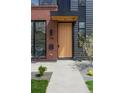 Eye-level view of the impressive wooden front door and manicured landscaping at 716 S Race St, Denver, CO 80209