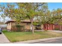Single-story brick home featuring a two-car garage and mature landscaping at 258 S 14Th Ave, Brighton, CO 80601