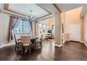 Elegant dining area with hardwood floors, coffered ceilings, chandelier, and modern furnishings at 4037 S Odessa Cir, Aurora, CO 80013