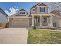 Inviting two-story house featuring a brick facade, front porch, and a double garage at 4037 S Odessa Cir, Aurora, CO 80013