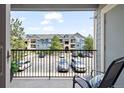 Balcony view overlooking the community buildings and parking area under a partly cloudy sky at 4451 S Ammons St # 4-203, Littleton, CO 80123