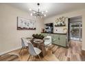 Modern dining room featuring an artistic light fixture and a clear glass dining table, offering a blend of style and comfort at 1103 S Monaco Pkwy, Denver, CO 80224