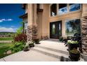 Elegant front entrance with stone accents, a welcoming porch, and beautiful flower planters at 19735 Knights Xing, Monument, CO 80132