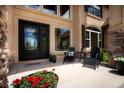 Inviting front porch with seating area and double door entry, enhanced by beautiful landscaping at 19735 Knights Xing, Monument, CO 80132