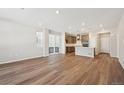 Inviting living space featuring hardwood floors and an open layout, with a modern kitchen in view at 7312 Watercress Dr, Littleton, CO 80125