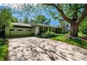 Charming home featuring a two-car garage, a spacious driveway, mature shade trees, and manicured lawn at 990 S Jackson St, Denver, CO 80209