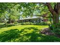 Beautiful home with a lush green lawn, mature trees, and professionally maintained landscaping at 990 S Jackson St, Denver, CO 80209