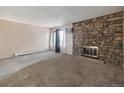 Spacious living room with stone fireplace and natural light at 381 S Ames St # G101, Lakewood, CO 80226