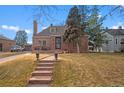 Charming brick home featuring a landscaped front yard, stone steps, and a welcoming entrance at 1545 Locust St, Denver, CO 80220
