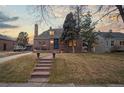 Charming brick home featuring a landscaped front yard, stone steps, and a welcoming entrance at 1545 Locust St, Denver, CO 80220