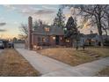 Charming brick home featuring a landscaped front yard, stone steps, and a welcoming entrance at 1545 Locust St, Denver, CO 80220